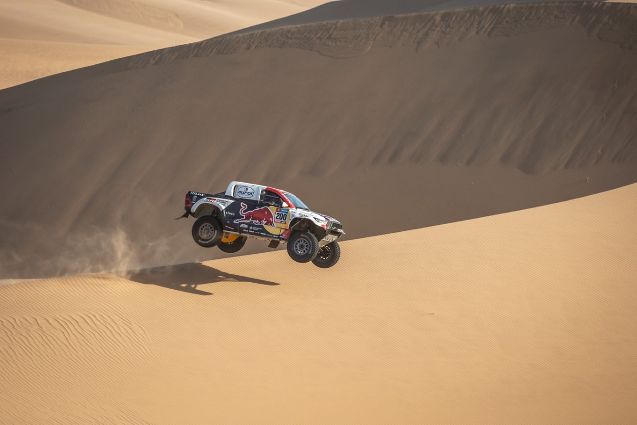 Hilux gliding through the air in desert