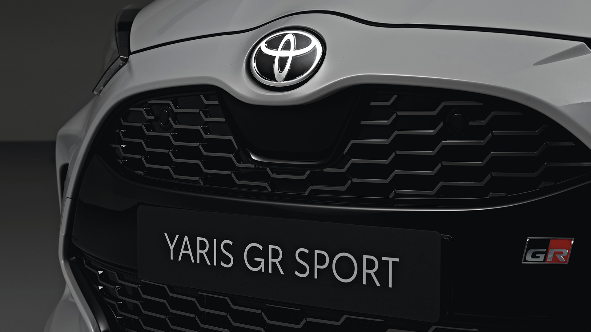 Model shown is Yaris GR SPORT  in bi-tone Dynamic Grey Night Sky Black roof (2RZ) and GR SPORT black fabric with red stitching seat